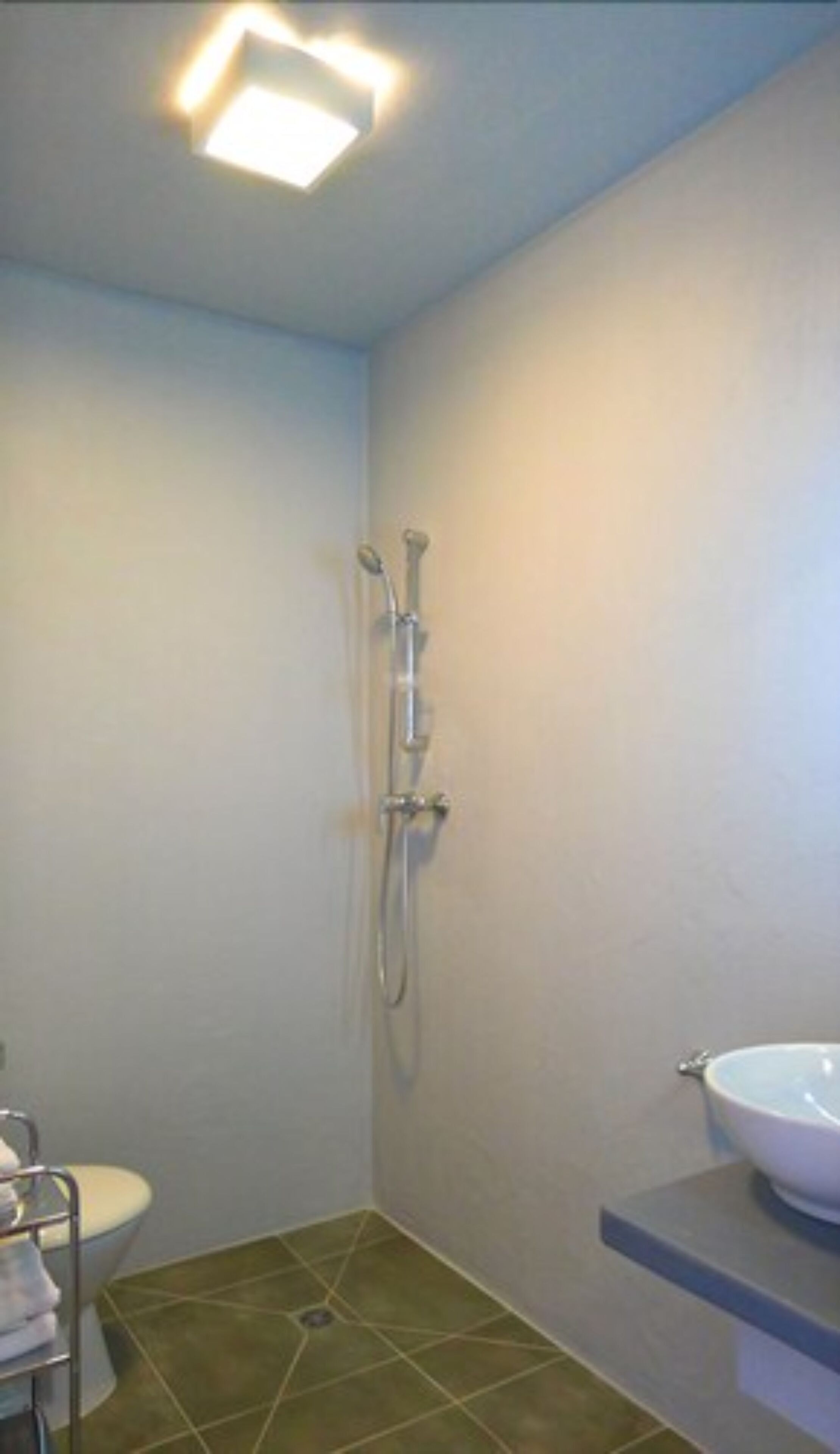 A small bathroom with a shower, toilet, and sink.
