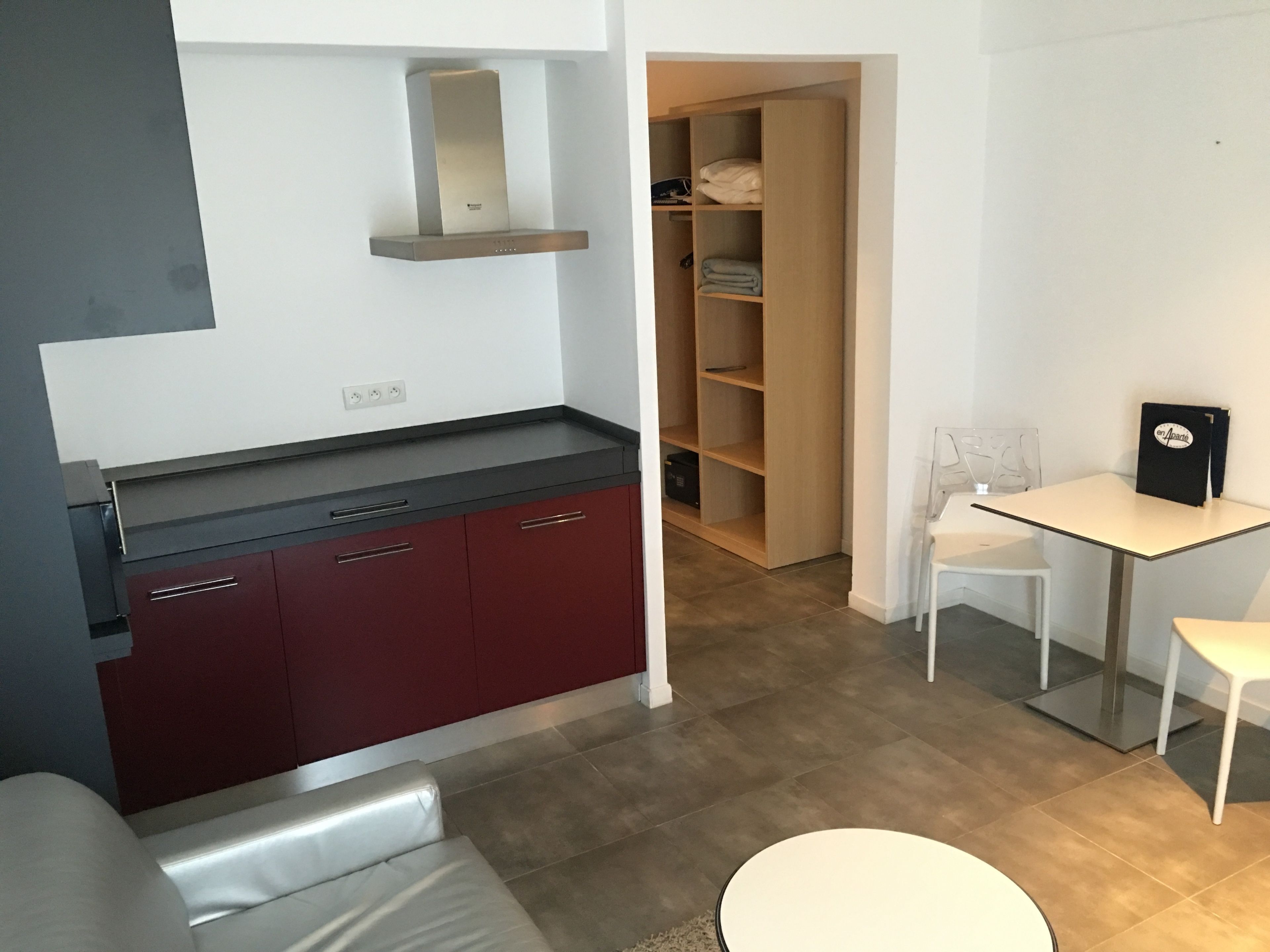 Une cuisine moderne dotée d’une cuisinière intégrée, d’un meuble en bois et d’un coin repas avec une table et des chaises.