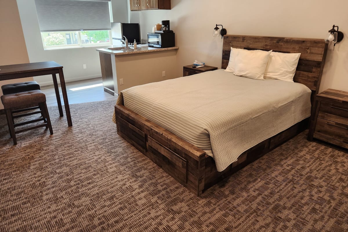 Ein Schlafzimmer mit einem hölzernen Bett, einem Nachttisch, einem Schreibtisch und einem Stuhl.