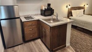 Cocina compacta con refrigerador, microondas y cafetera.