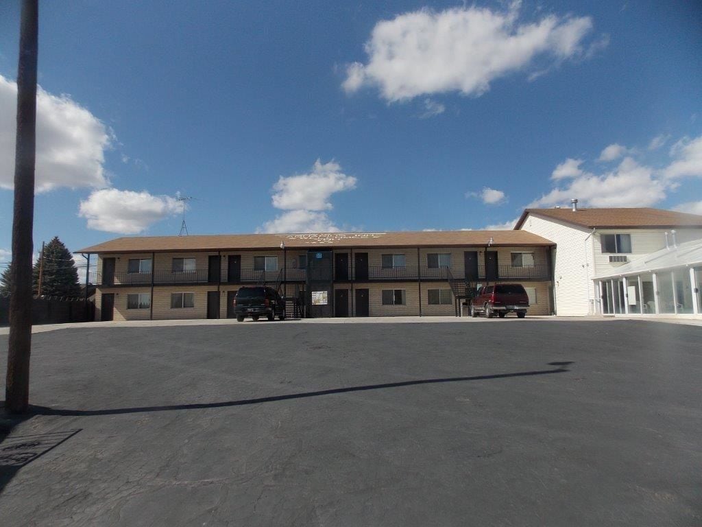 A two-story motel with a parking lot in front.