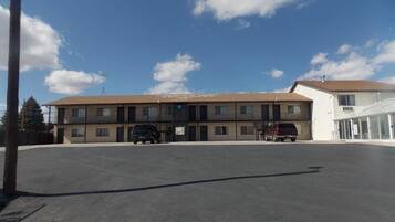 A two-story motel with a parking lot in front.