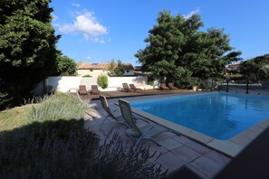 Een seizoensgebonden buitenzwembad en parasols bij het zwembad