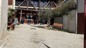 A building with a wooden balcony and a gravel driveway. - The Resid For Calixte (Perouges)