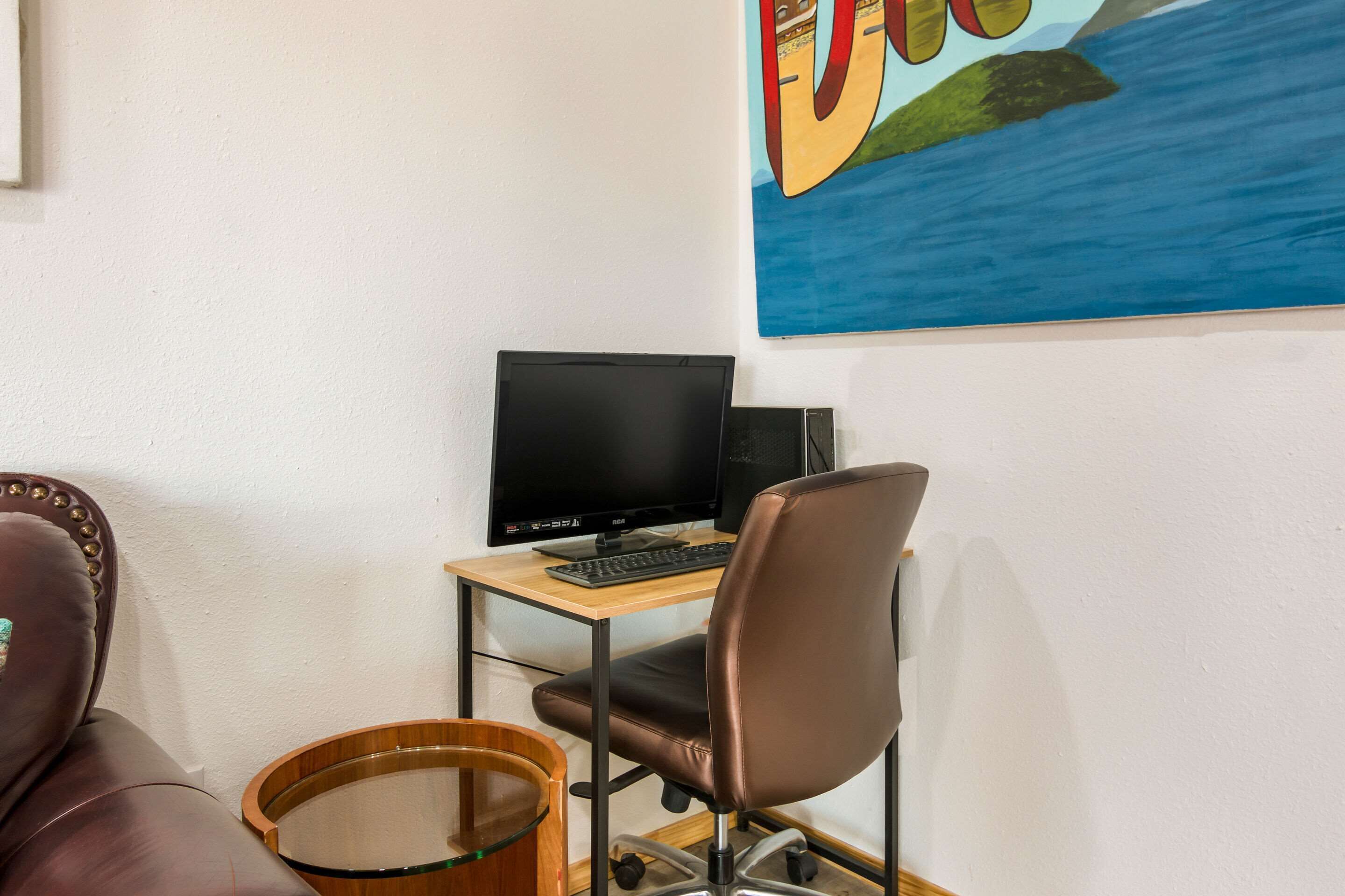 Una habitación con un escritorio, una computadora, una silla y una batería.