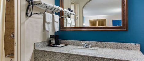 A bathroom with a sink, mirror, towel rack, and hairdryer.