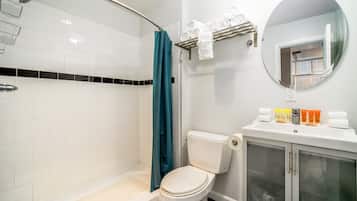 Une salle de bain équipée d’une douche, de toilettes et d’un lavabo avec des articles de toilette.