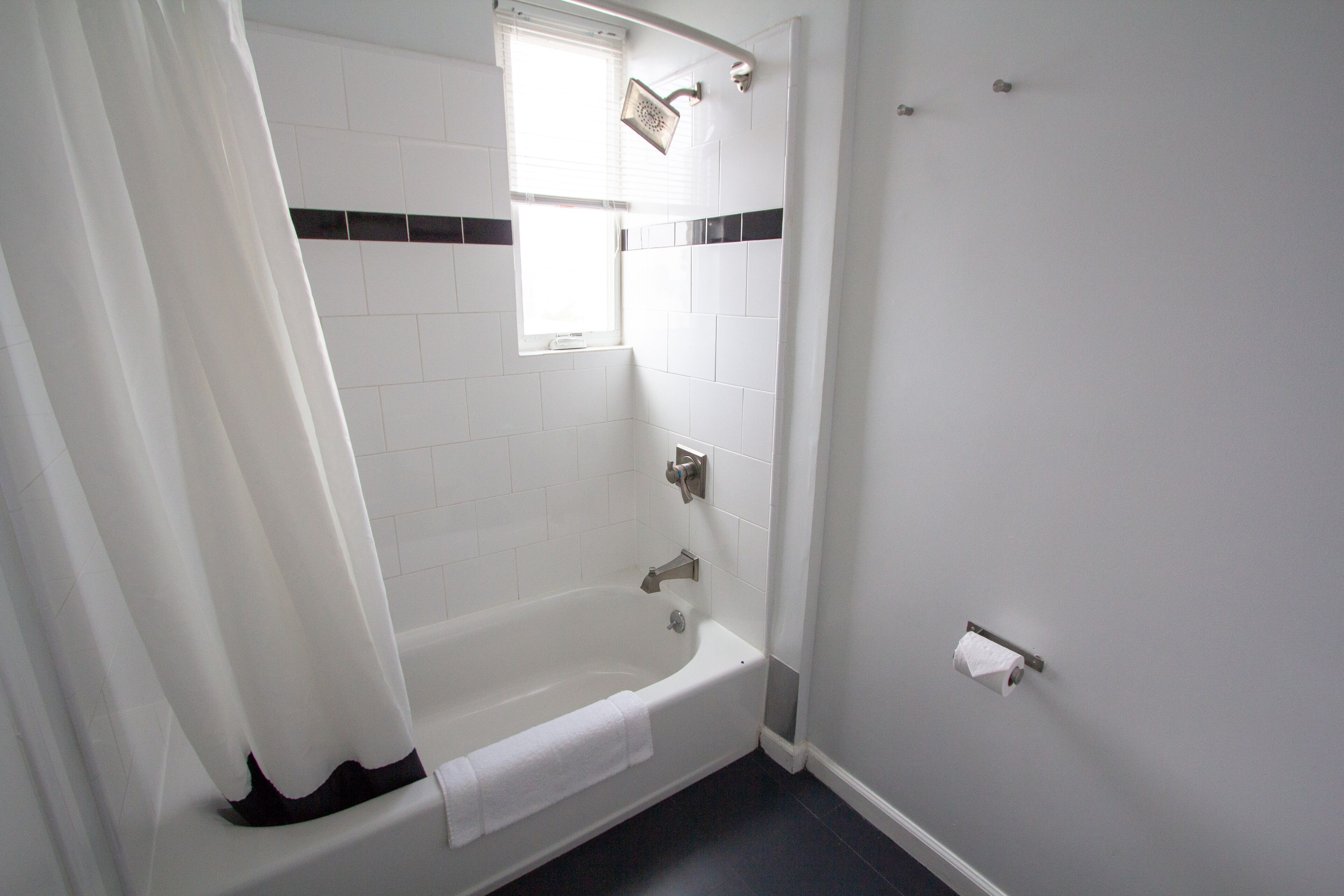 Un baño con bañera, ducha y ventana.