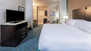 A hotel room with a bed, a TV, a desk, and a chair.