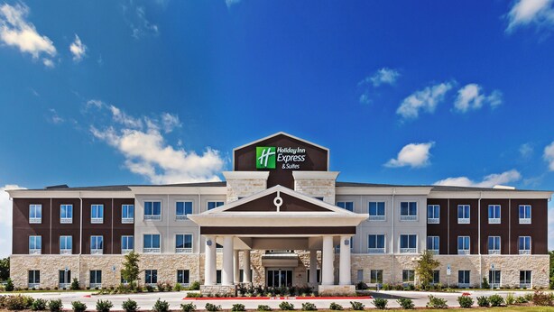 A Holiday Inn Express & Suites hotel with a stone facade, multiple windows, and a clear blue sky. - Holiday Inn Express & Suites Killeen - Fort Hood Area by IHG (Killeen)