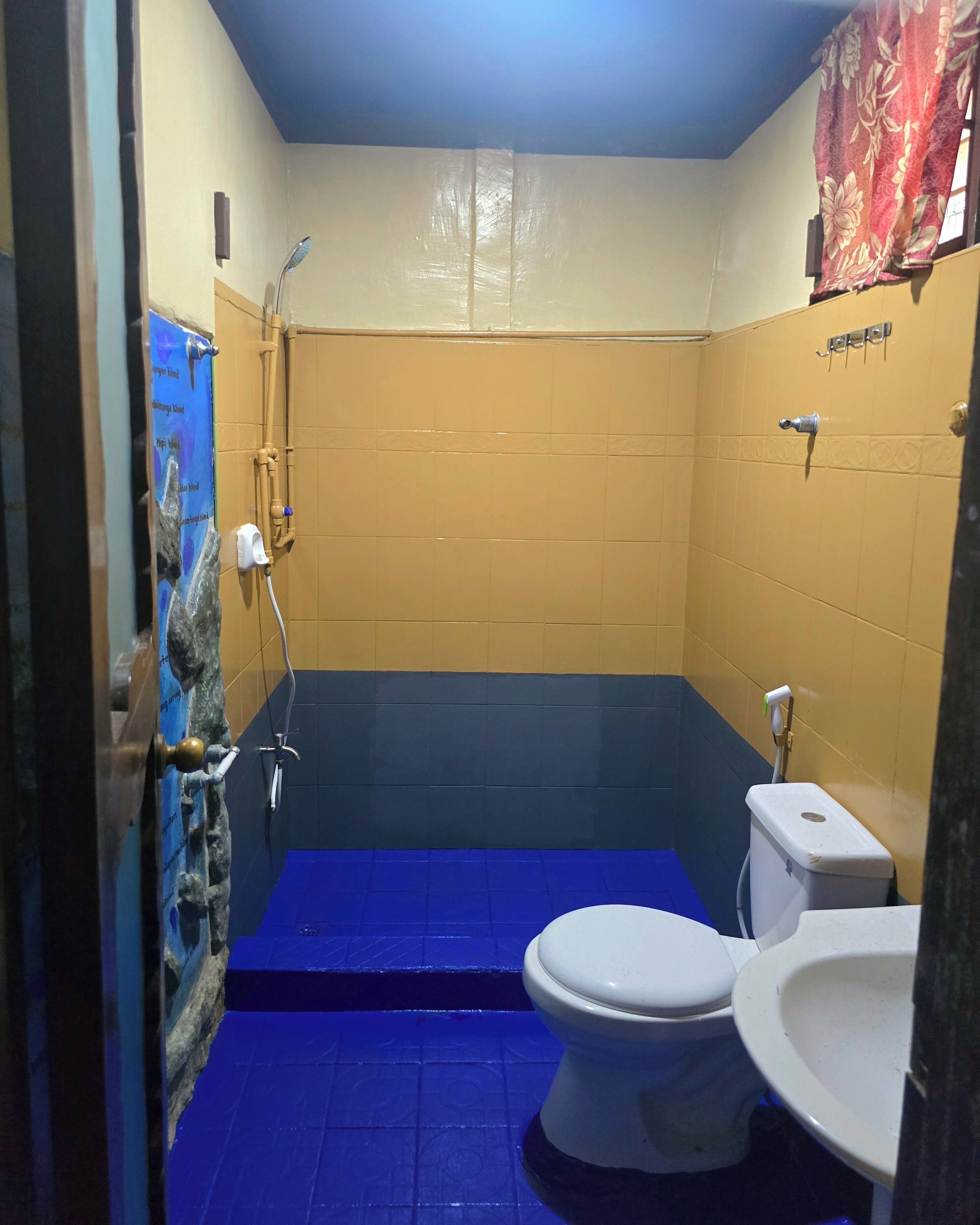 Un baño pequeño con cabina de ducha azul, inodoro blanco y lavabo.