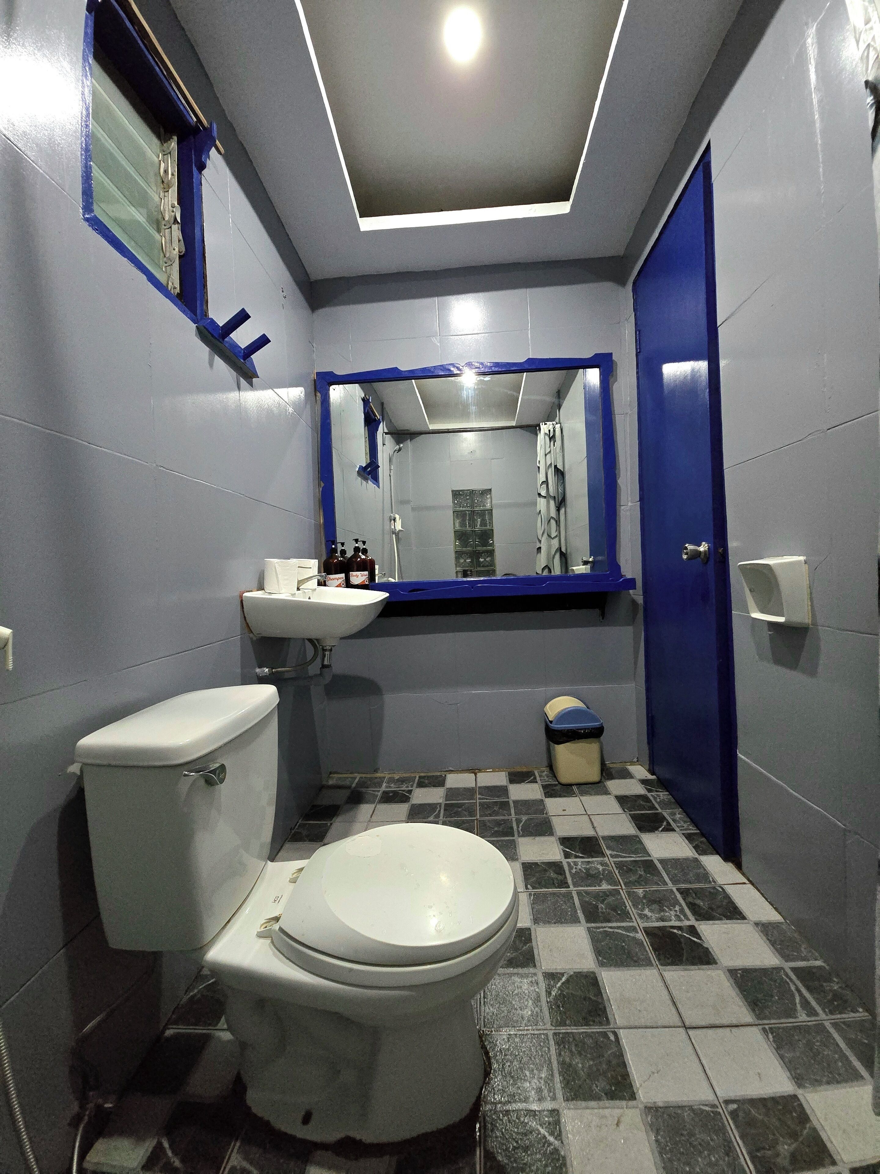Un baño pequeño con inodoro, lavamanos y espejo.