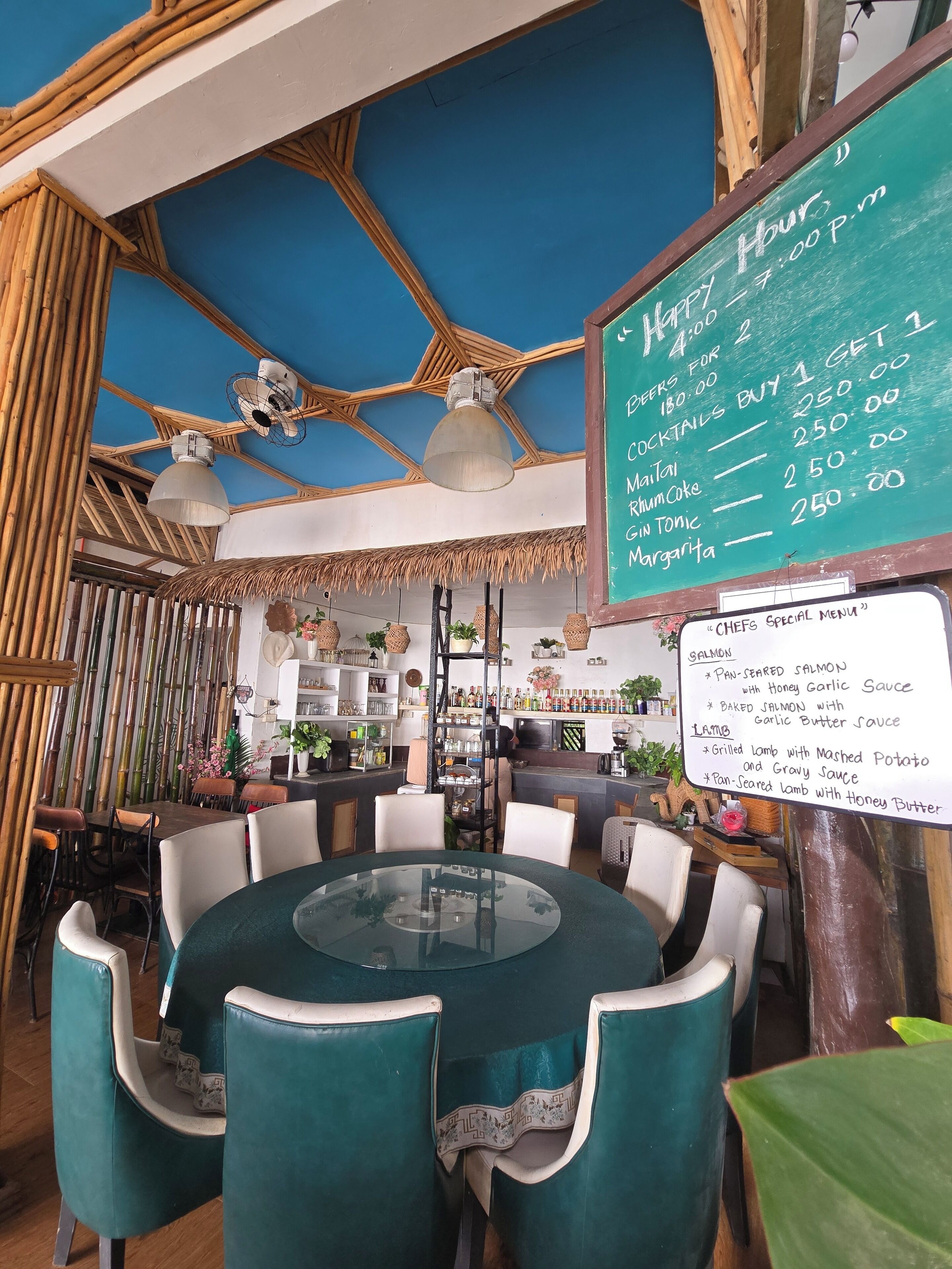 A restaurant with a bamboo ceiling, a chalkboard menu, and a 'CHEFS SPECIAL MENU' sign listing items like salmon and lamb.