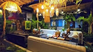 A cozy indoor seating area with a sofa, a small table, and decorative items. - Islandfront Cottages (El Nido)