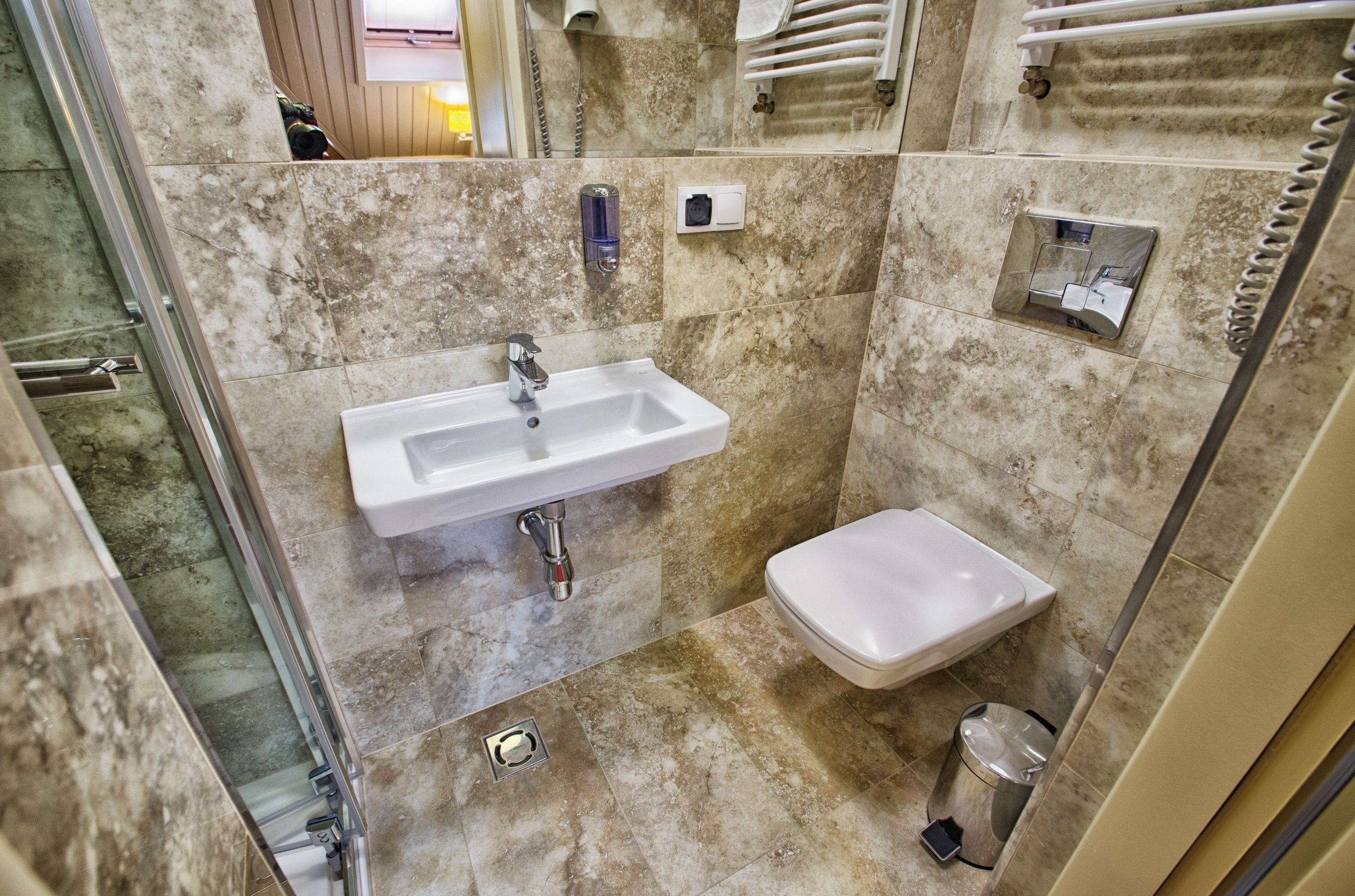 Baño con lavamanos, inodoro y zona de ducha.