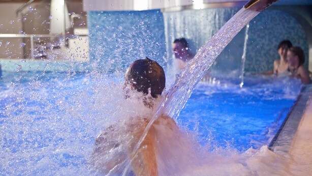 Una persona nadando en una piscina con agua salpicando a su alrededor.