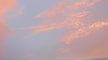 A sky with scattered clouds and a gradient of colors from blue to pink.