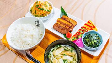 A tray with various dishes including rice, noodles, and a bowl of soup.