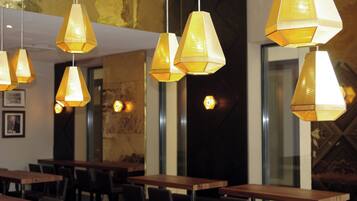 Ein Restaurantinneres mit mehreren Tischen und hängenden Lampen.