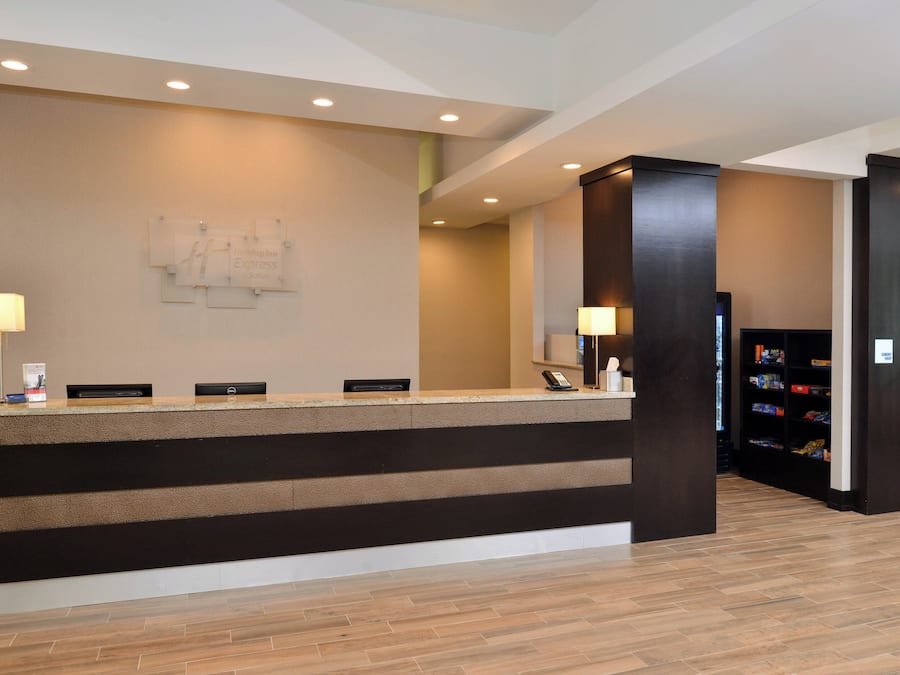 A hotel reception desk with a modern design, a reception area, and a small retail shop.