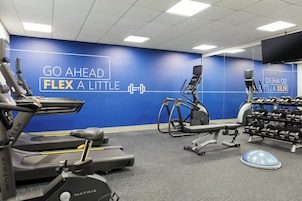 A gym with treadmills, an elliptical, and a weight bench.