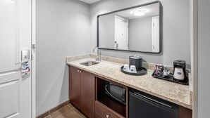 A modern bathroom with a granite countertop, a sink, a coffee maker, and a mirror. - Hampton Inn & Suites Camp Springs/Andrews AFB (Suitland)