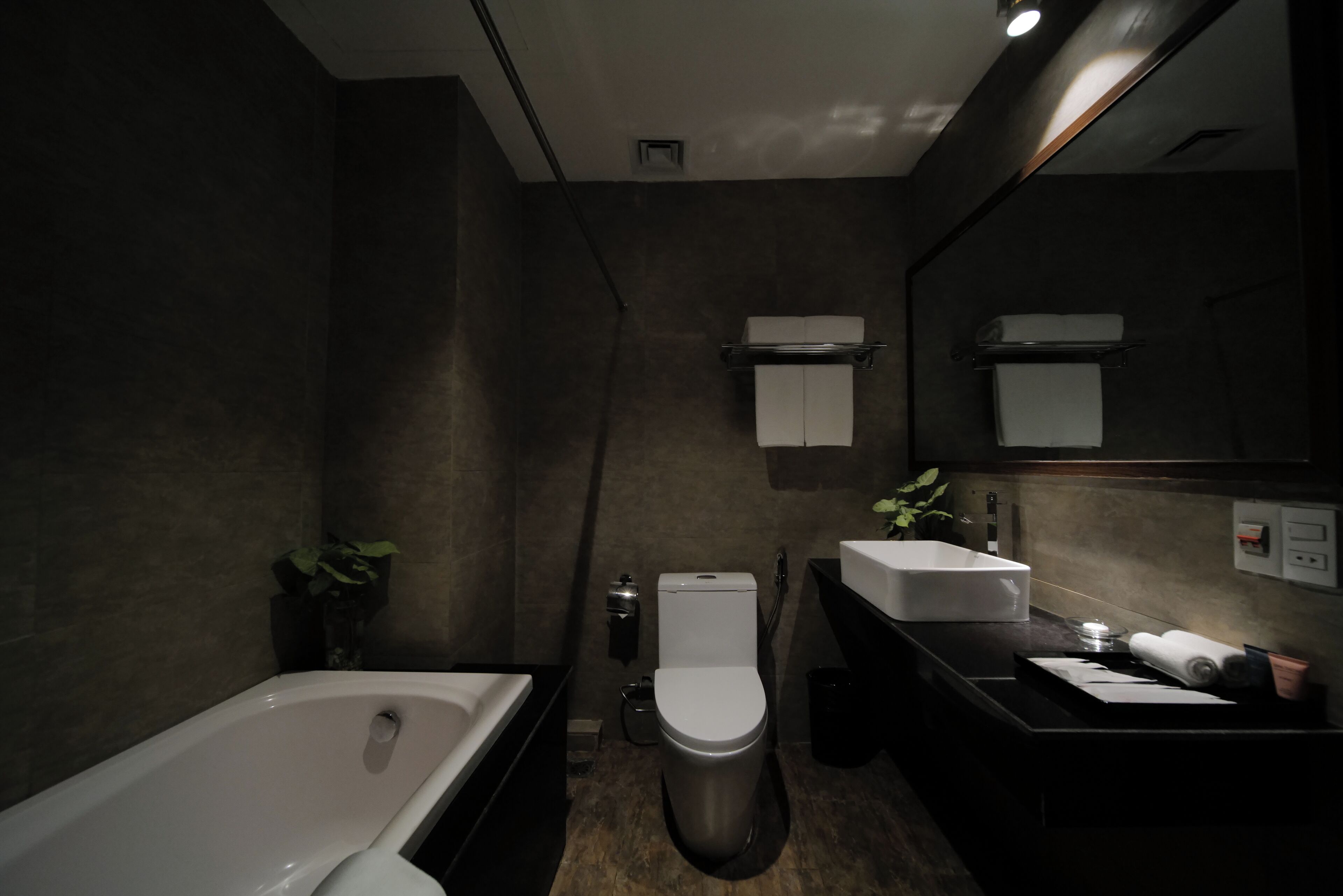A modern bathroom with a bathtub, toilet, and vanity.