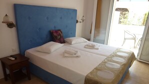 Une chambre d’hôtel avec un grand lit, une petite table de chevet et une vue sur l’extérieur.