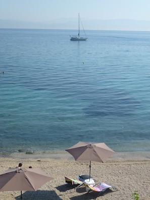 En la playa, sillas reclinables de playa, sombrillas