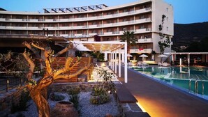 Ein Hotel mit Pool, Außenbereich und einem großen Baum.