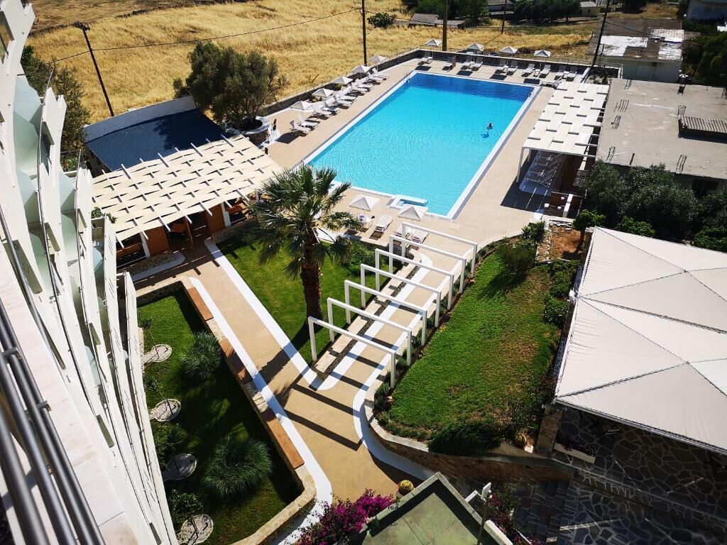 A rooftop swimming pool with lounge chairs and a small garden area.