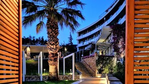 Ein Weg, der zu einem Gebäude mit einer Palme und einer Treppe führt.