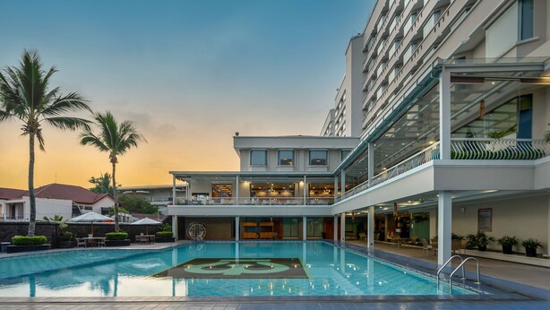 Ein Hotel mit Pool, Sitzgelegenheiten im Freien und moderner Architektur.