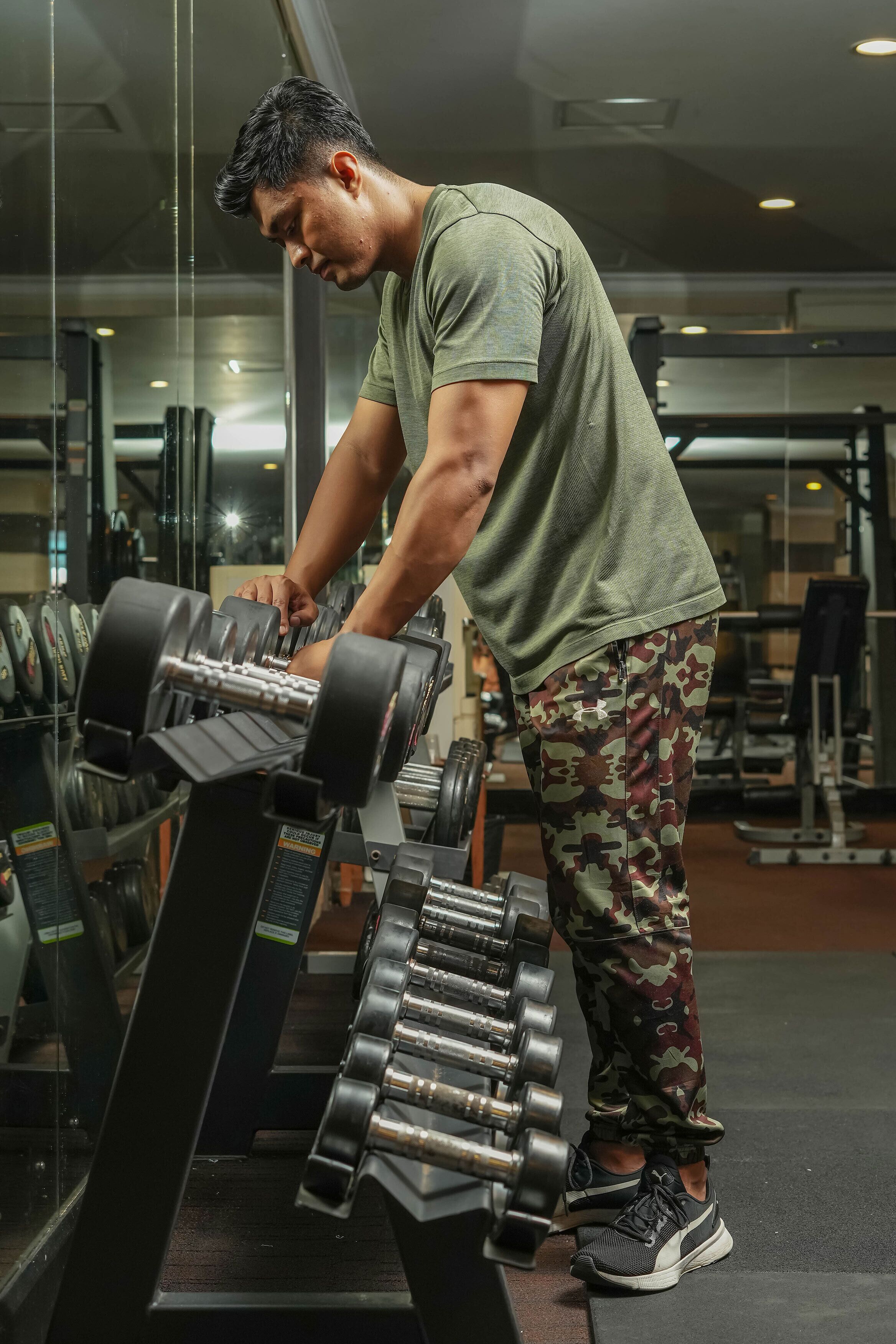 A gym with exercise equipment, including dumbbells and a bench.