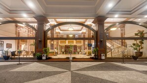 Eine Hotelhalle mit einem imposanten Eingangsbereich, einer Treppe und einer Rezeption.