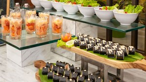 Ein reichhaltiges Buffet mit verschiedenen Speisen, darunter Sushi, Salate und Getränke.