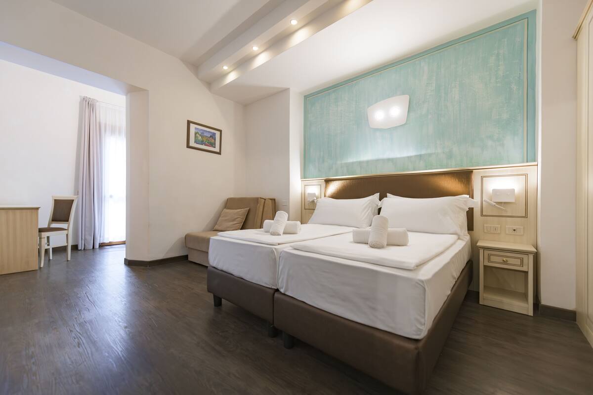 Een hotelkamer met een groot bed, een nachtkastje, een stoel en een bureau.