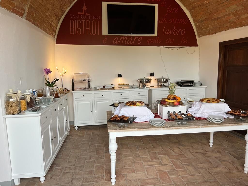 A breakfast buffet setup with a variety of food items and a TV mounted on the wall.