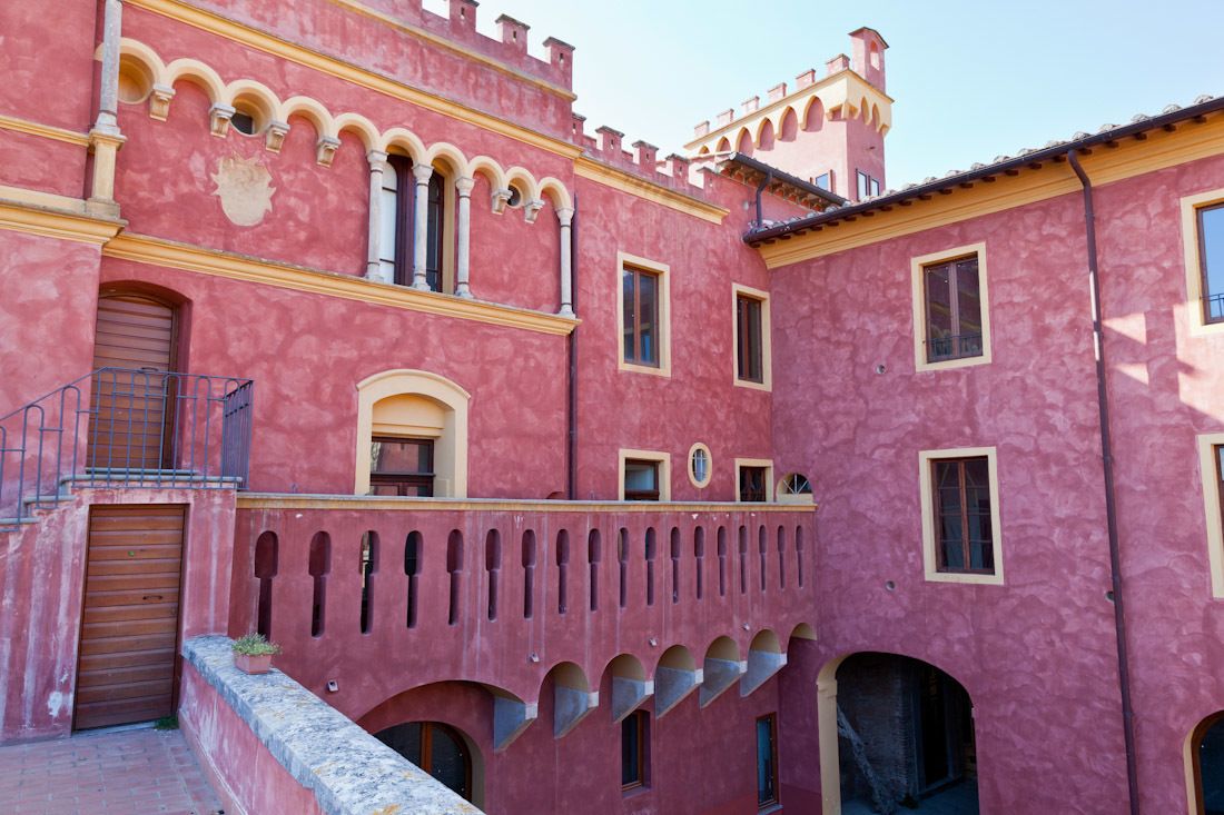 A pink building with arched windows and balconies.