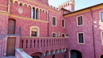 A pink building with arched windows and balconies.