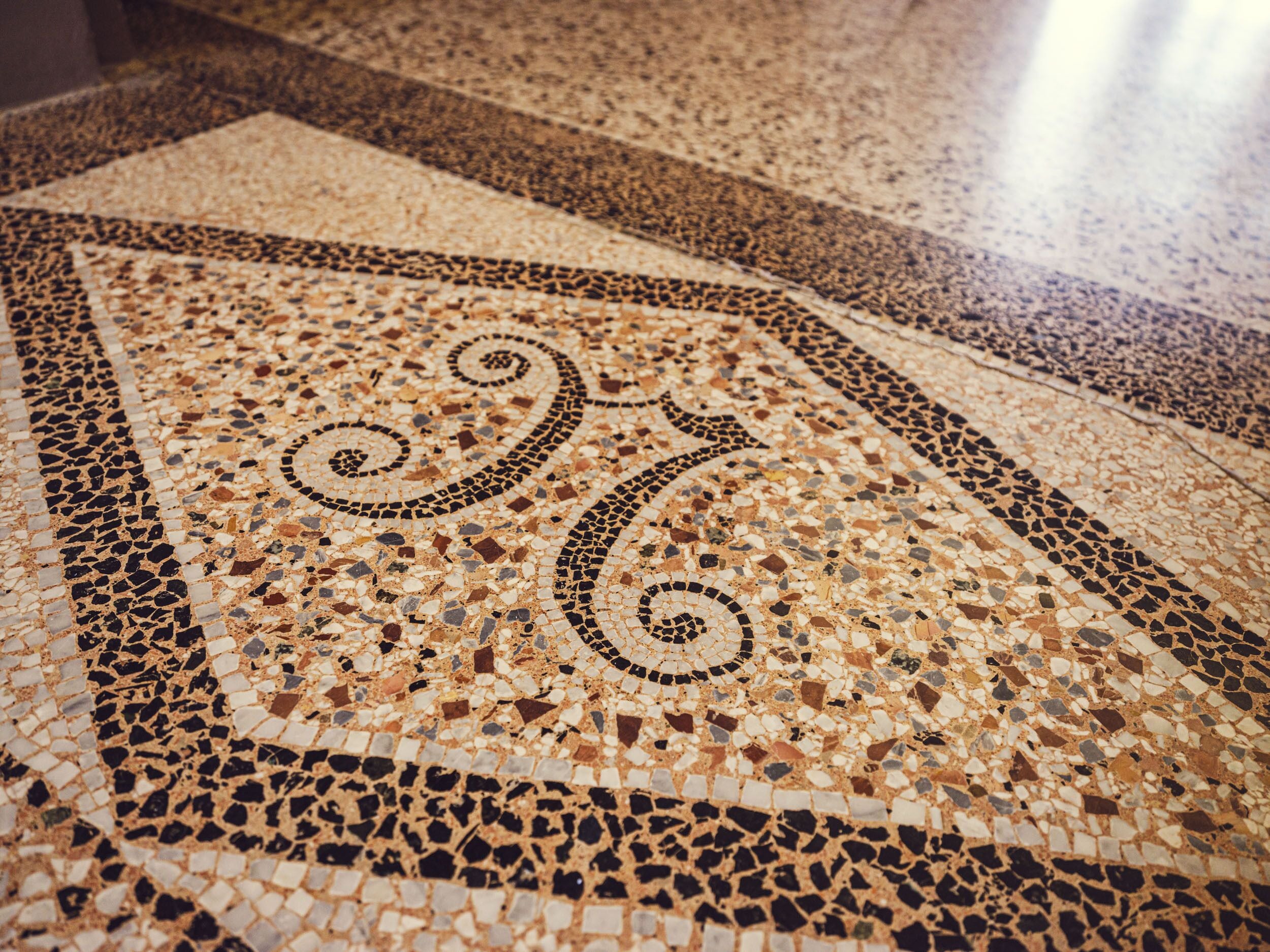 Un detallado suelo de mosaico con diseños y patrones intrincados.
