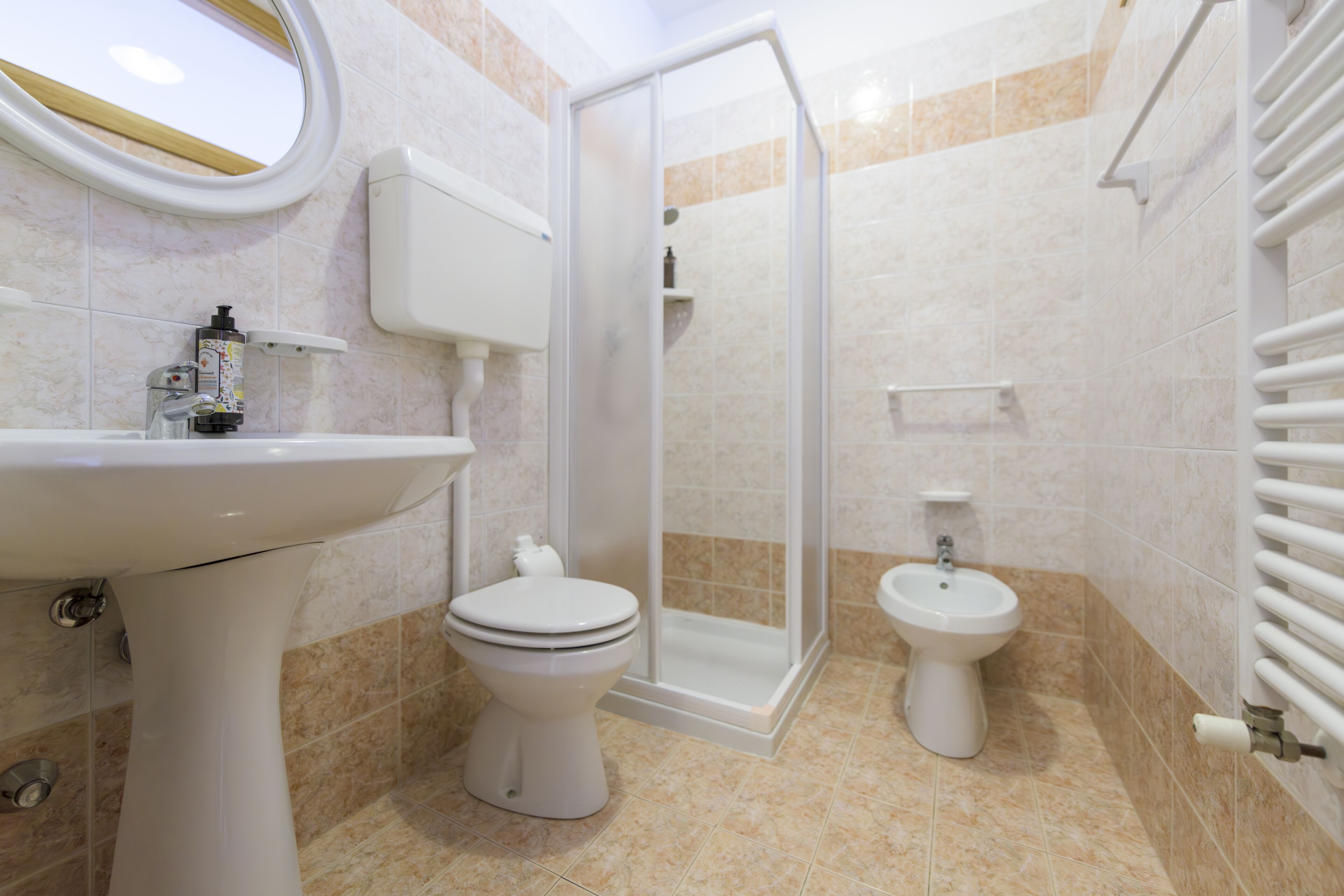 Un baño con inodoro, bidé y cabina de ducha.
