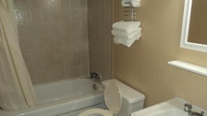 A bathroom with a bathtub, toilet, and sink. - Oasis Motel (Niagara Falls)