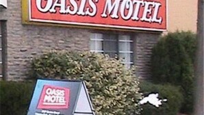 A motel sign with the name "Oasis Motel" and a signboard in front of it. - Oasis Motel (Niagara Falls)