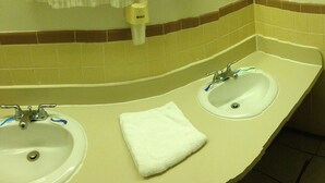 Une salle de bain avec deux lavabos, des toilettes et une baignoire.