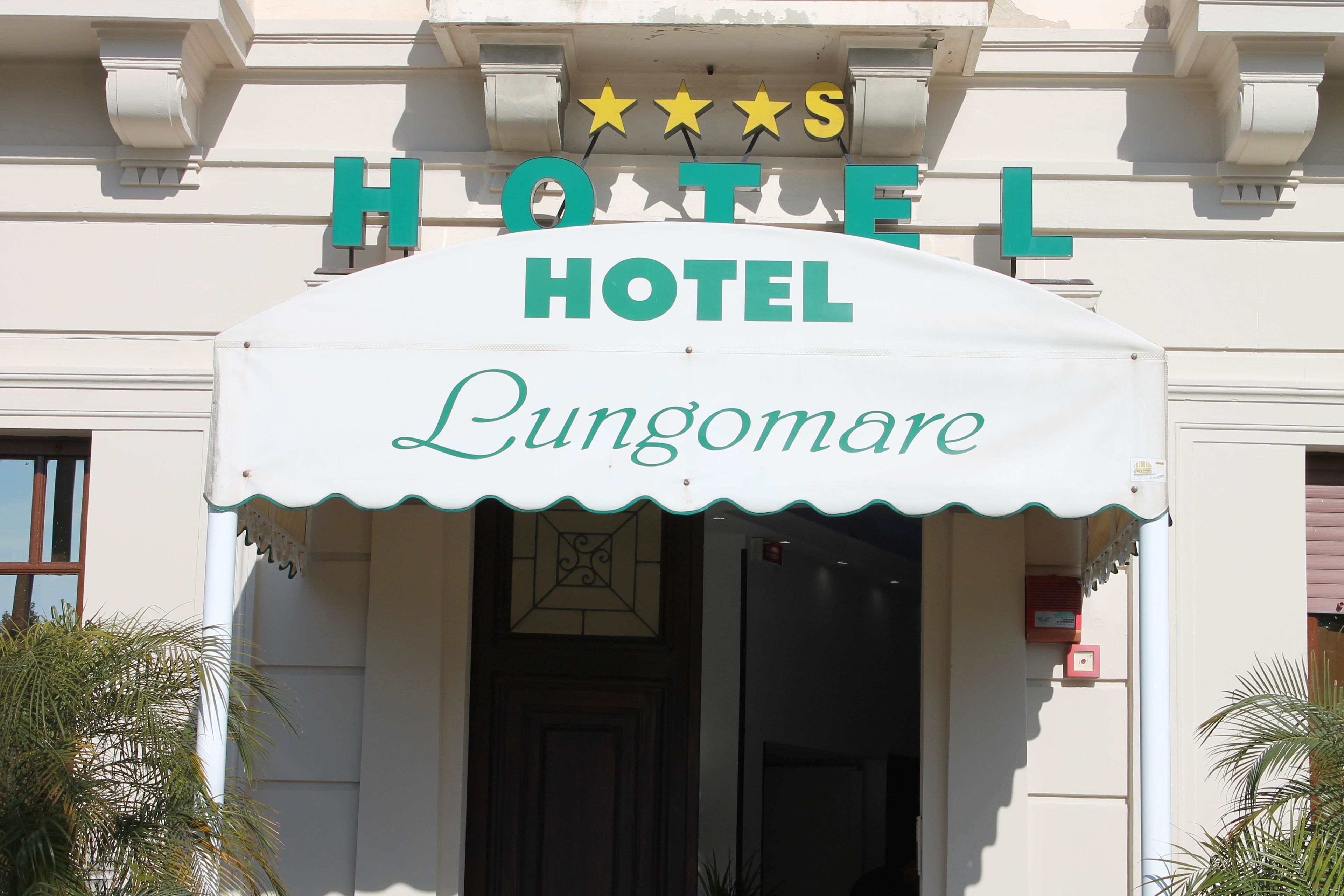 Ein Hotelschild mit dem Schriftzug 'Hotel Lungomare' und einer Drei-Sterne-Bewertung.