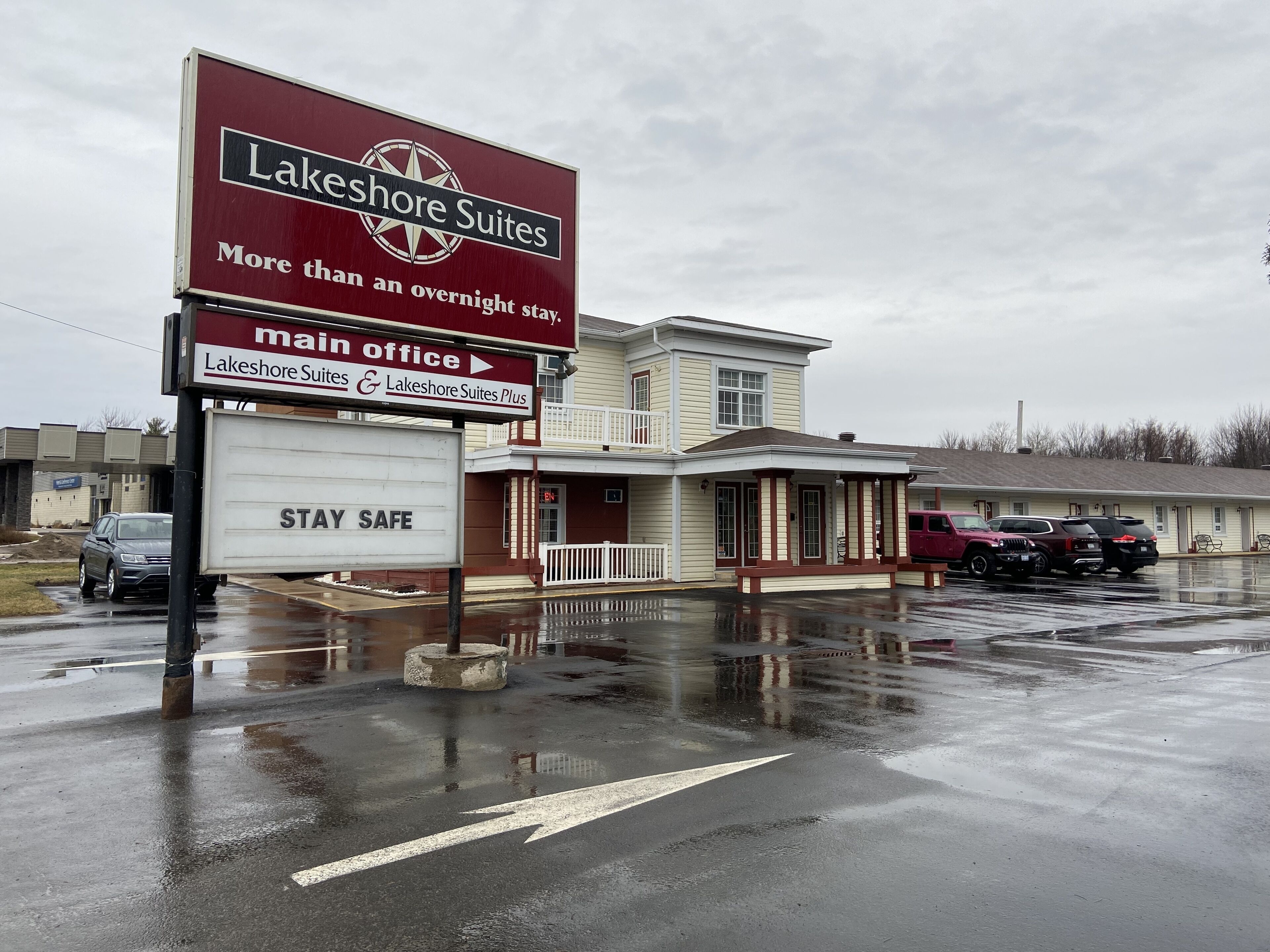 A Lakeshore Suites main office building with a sign indicating the direction to the main office.