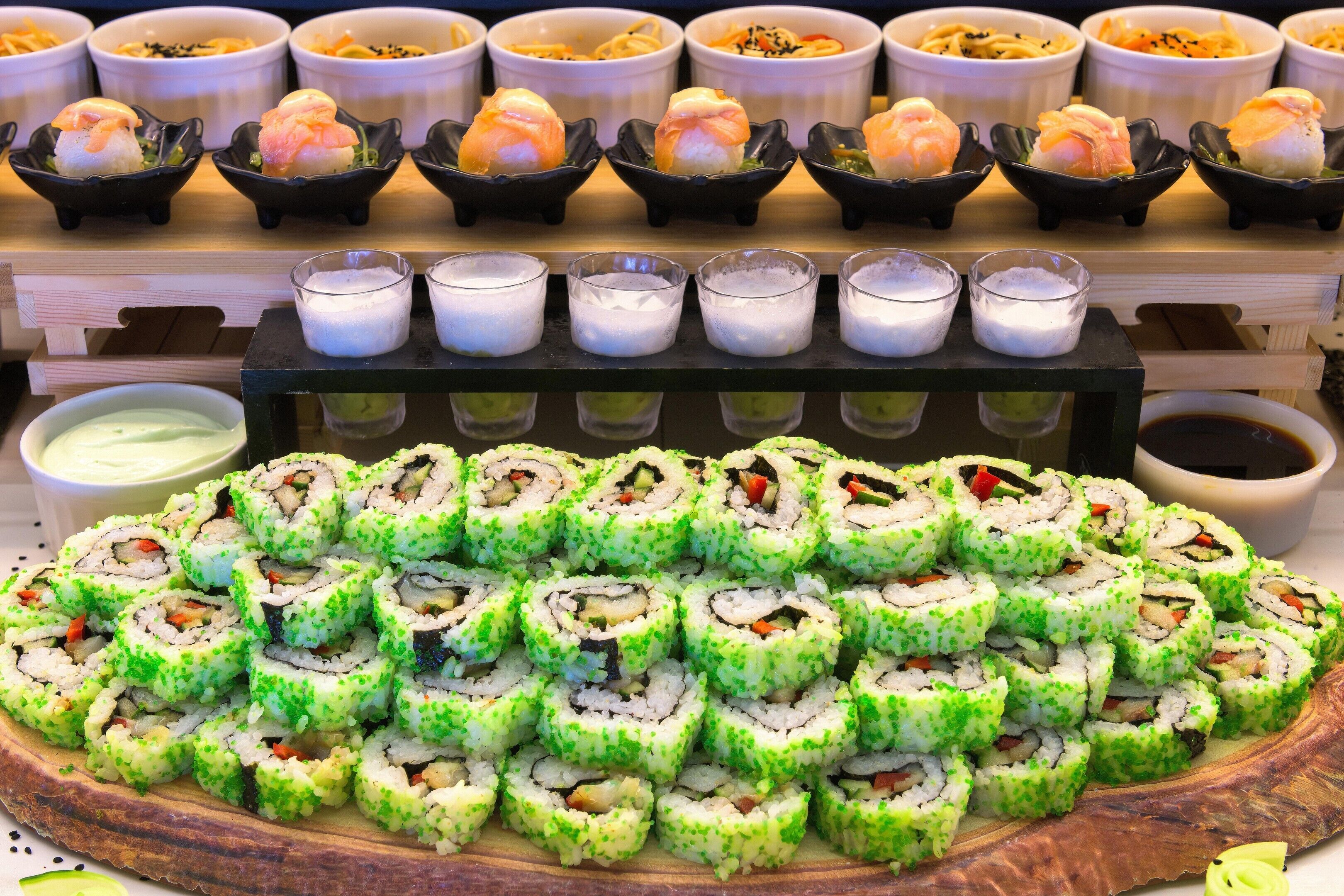 Sushi rolls and small dishes on a wooden table.