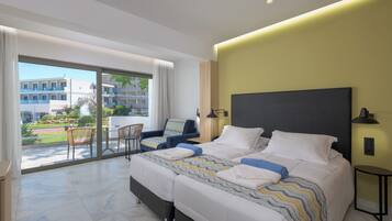 A modern hotel room with a large bed, a balcony with a dining area, and a view of the cityscape.