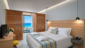 Un dormitori modern amb un llit gran, capçalera de fusta i vistes a la platja.